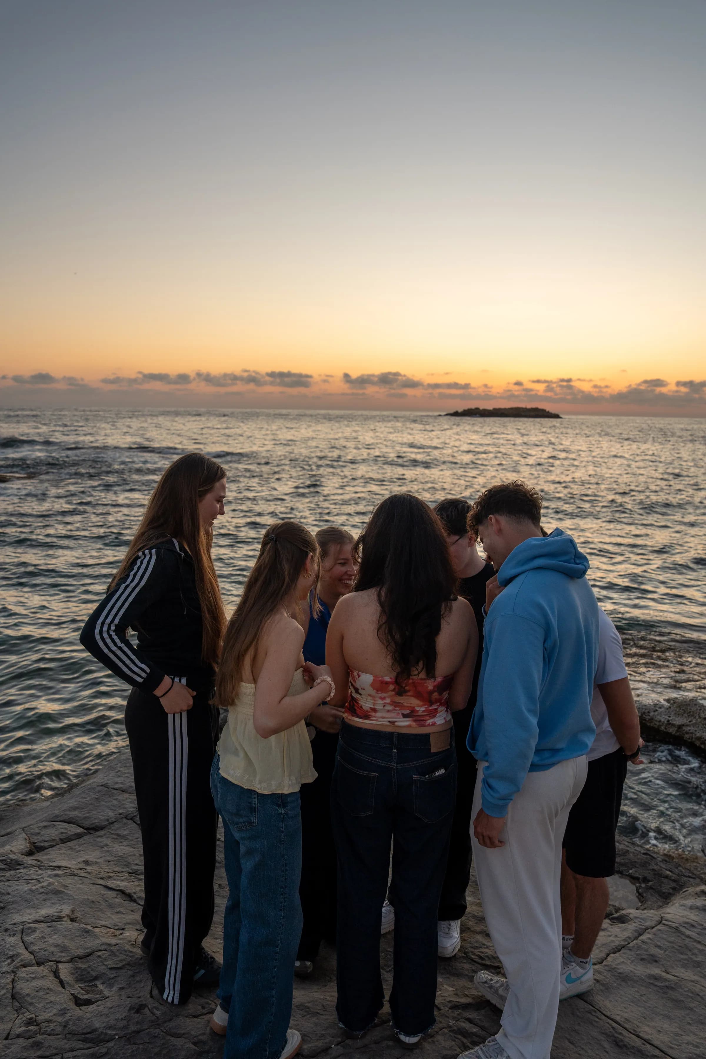 MOHANA Gruppe als Silhouette eng zusammen vor dem Sonnenuntergang.